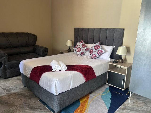 Bedroom with couch and colourful rug