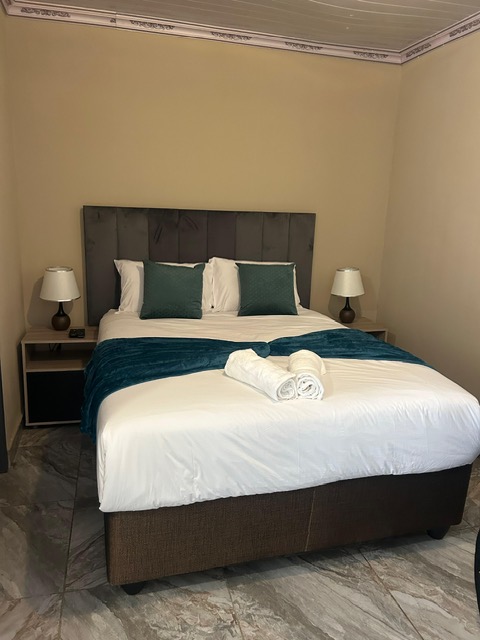 Bed with teal cushions and bedside lamps